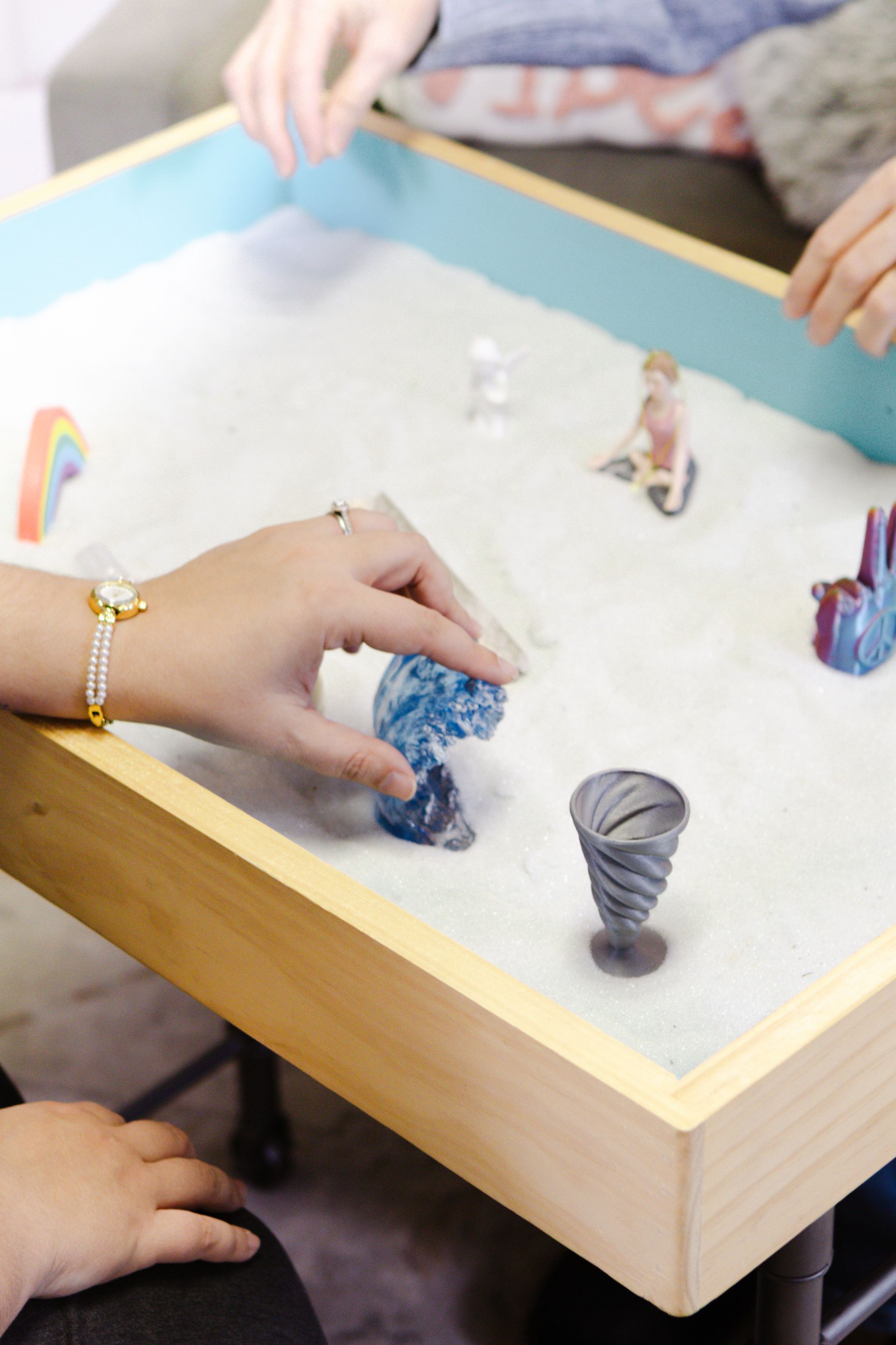 Sandtray with hands and miniatures