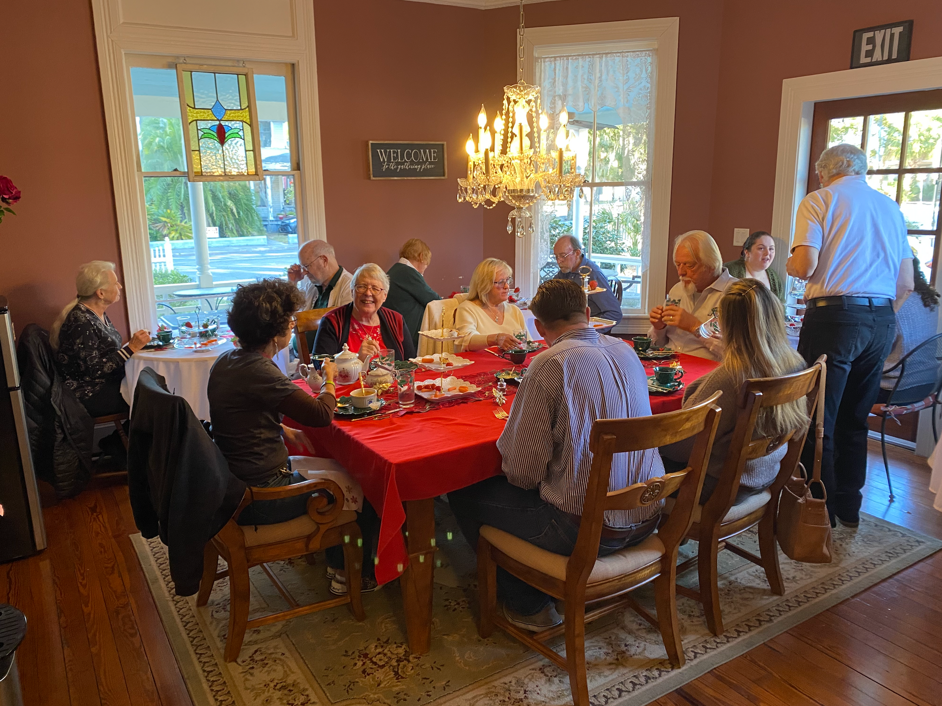 A group of happy people having afternoon tea at The Camellia Rose Inn.