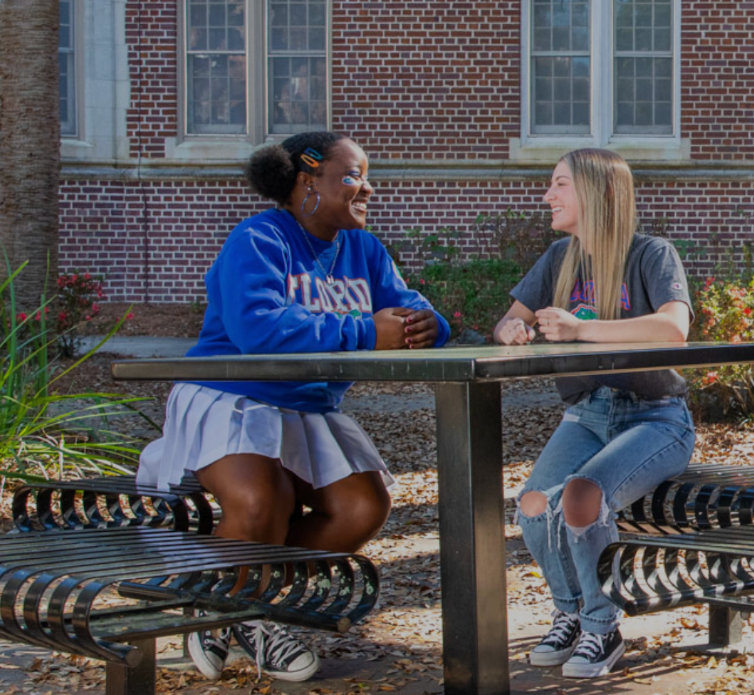 2 UF students sitting on a bench during UF Preview.
