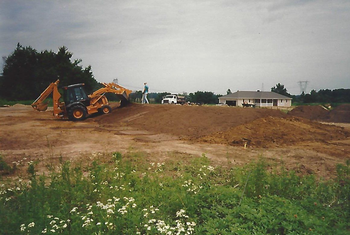 Worker and a Yellow Excavator Truck — Plymouth, IN — Creed Septic System Specialist