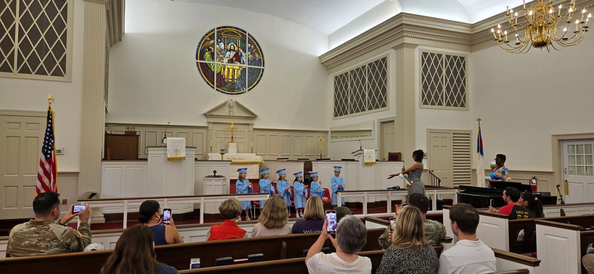 A line of young children in blue caps and gowns