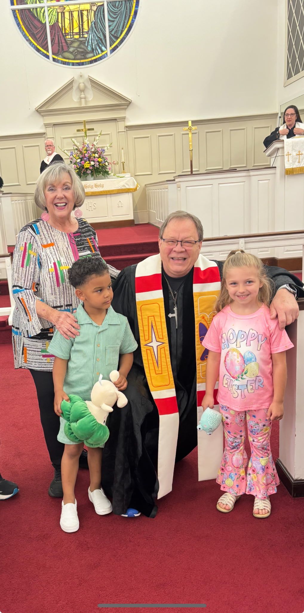 A man and a woman are posing for a picture with two children in a church.