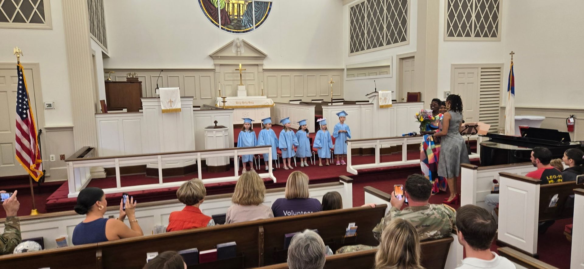 A line of young children in blue caps and gowns