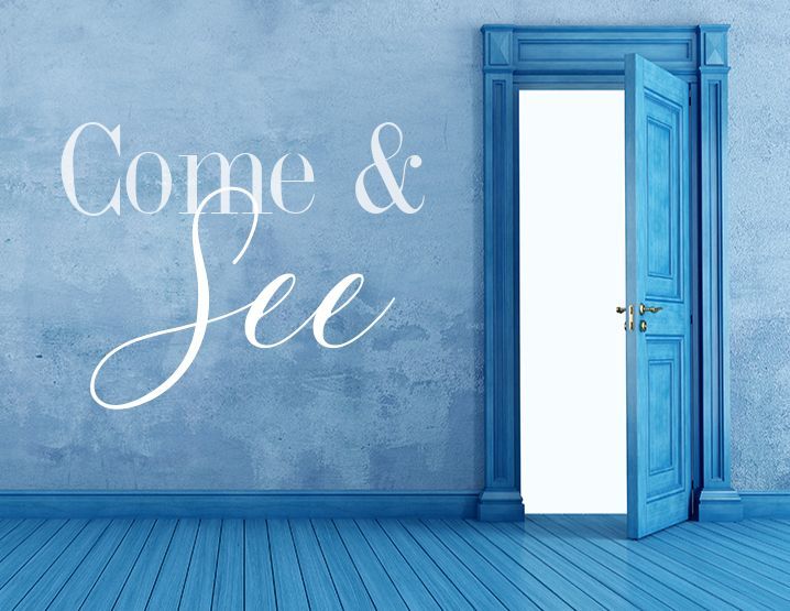 A blue door stands open inviting visitors to watch our welcome video