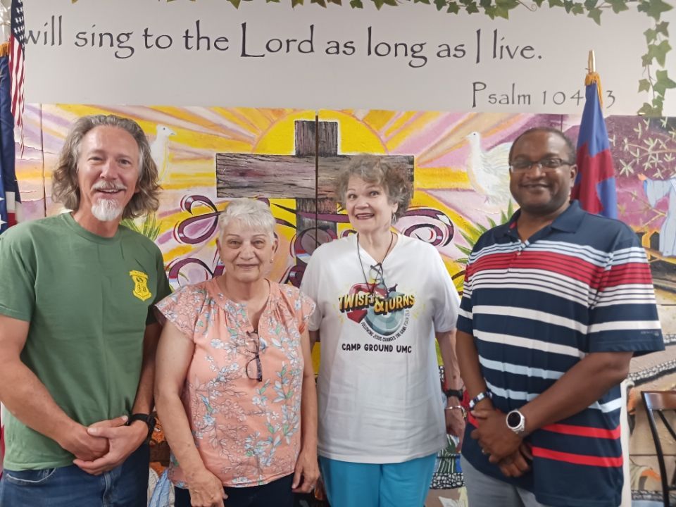 Crop Walk volunteers pose in front of a cross
