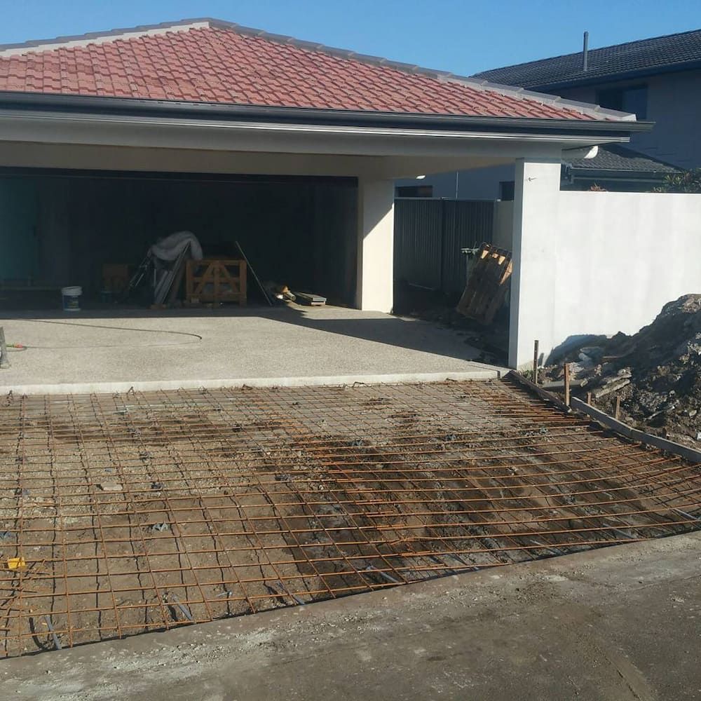 A House With a Red Tile Roof is Under Construction — TJ Concreting in Myocum, NSW