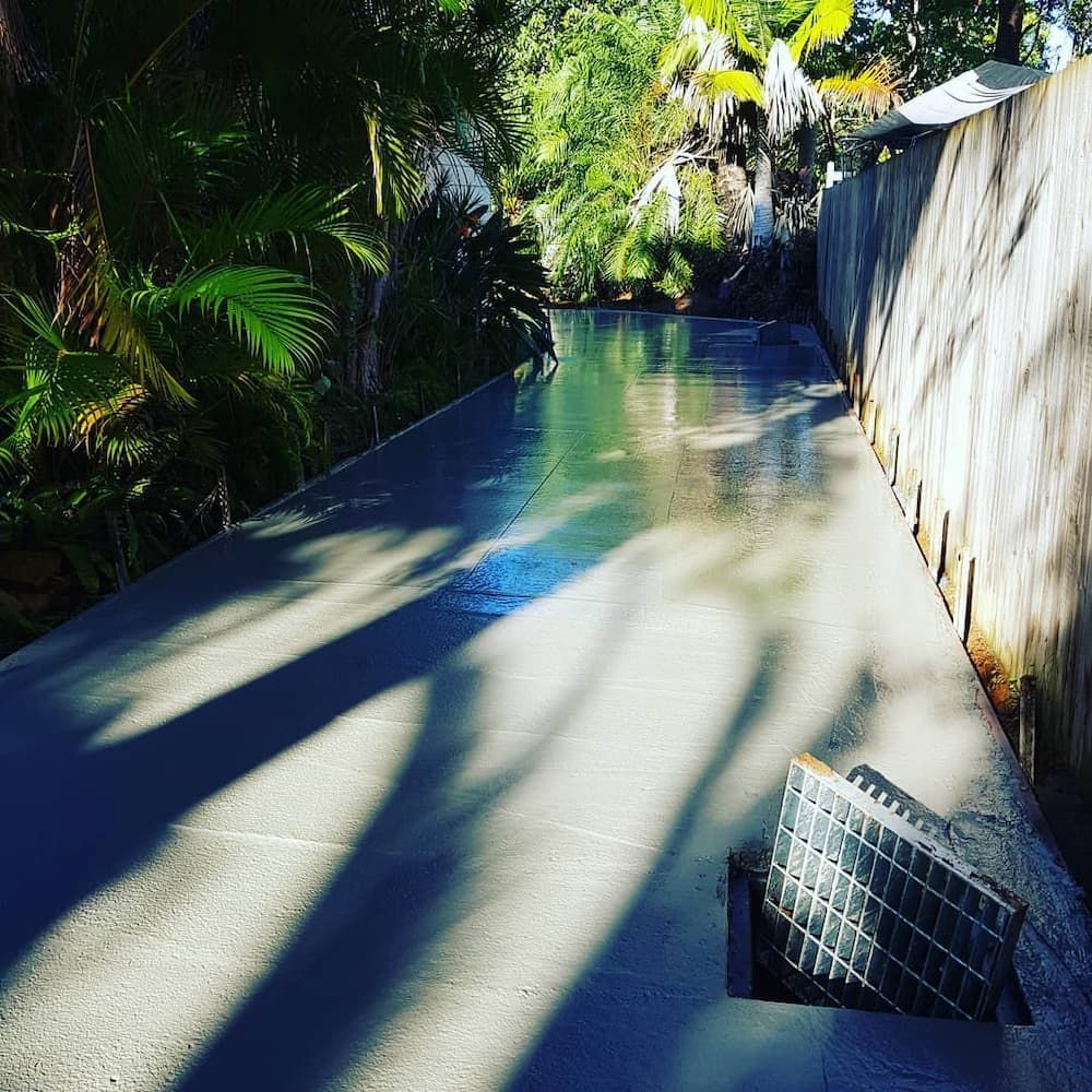 A Concrete is Surrounded by Trees and a Fence — TJ Concreting in Mullumbimby, NSW
