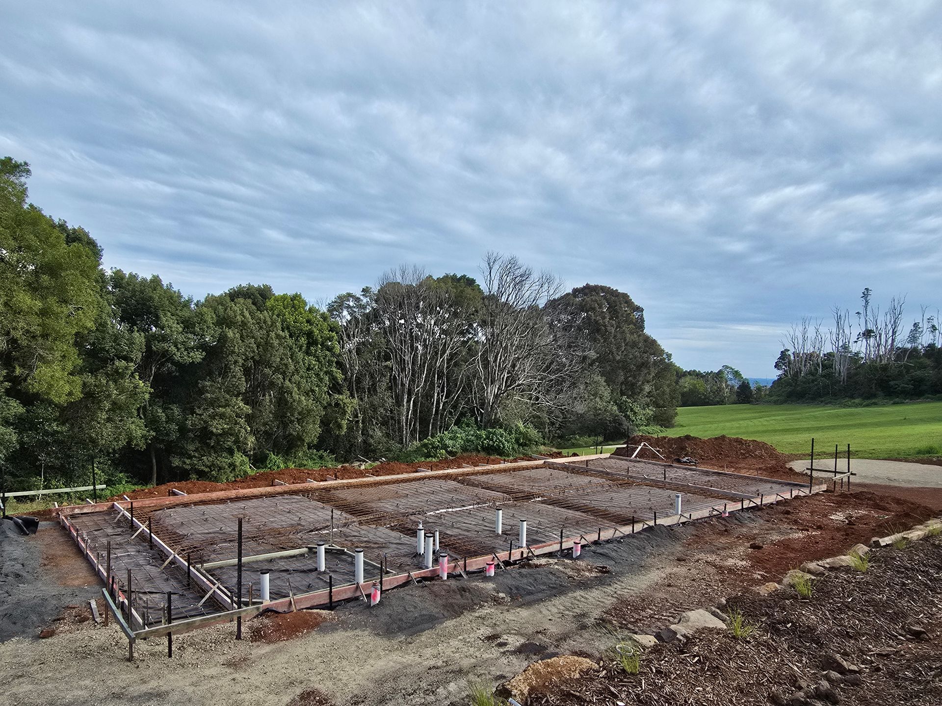 A Concrete Driveway is Being Built in Front of a House — TJ Concreting in Lismore, NSW