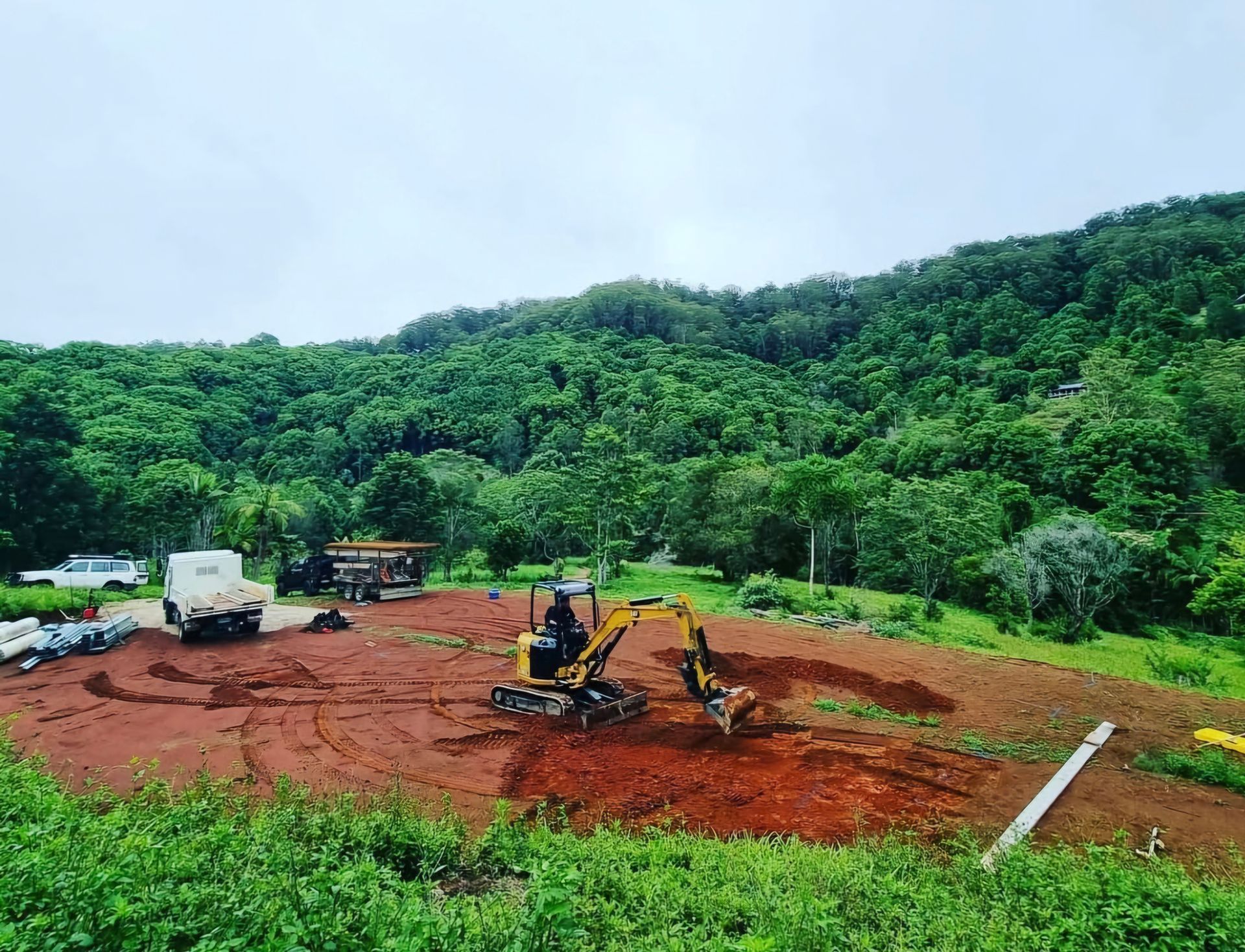 A Concrete Pump is Pouring Concrete on a Dirt Road — TJ Concreting in Myocum, NSW