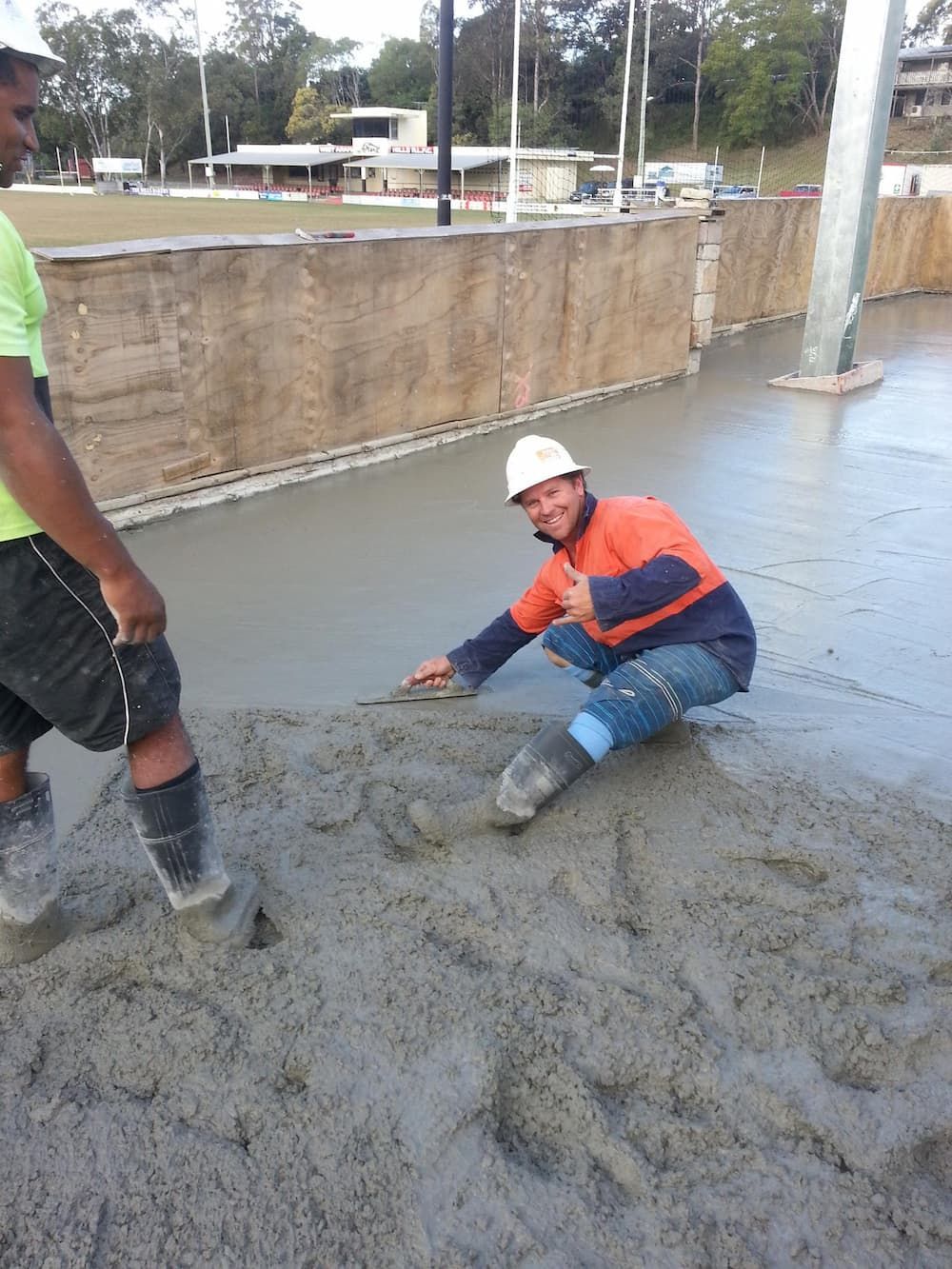 A Man in a Hard Hat is Kneeling on a Concrete Surface — TJ Concreting in Myocum, NSW