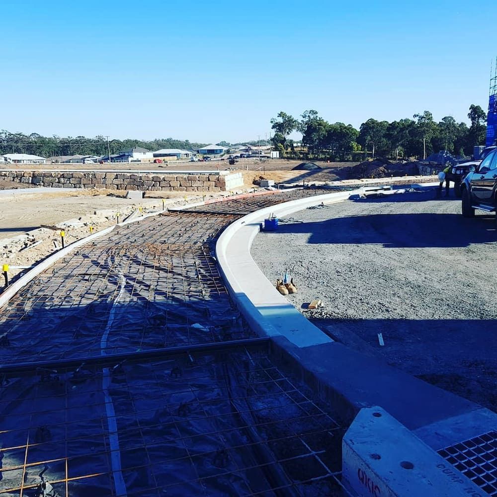 A Blue Truck is Parked on the Side of a Road Under Construction — TJ Concreting in Myocum, NSW