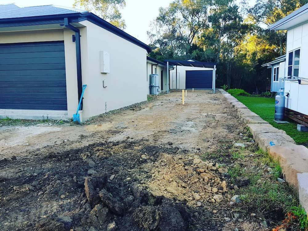 A Dirt Road Leading to a House With a Garage — TJ Concreting in Ballina, NSW