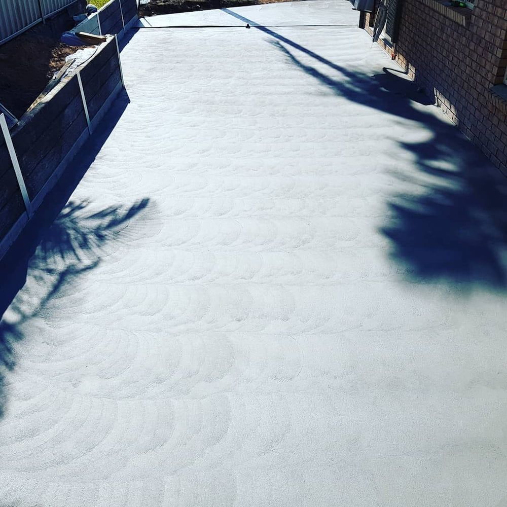 A Concrete Driveway With a Shadow of a Tree on It — TJ Concreting in Bangalow, NSW