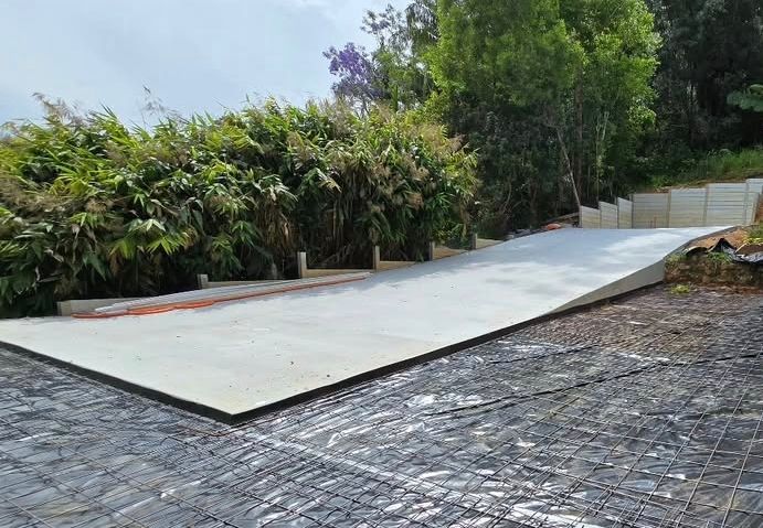 A Concrete Driveway is Being Built in Front of a House — TJ Concreting in Myocum, NSW