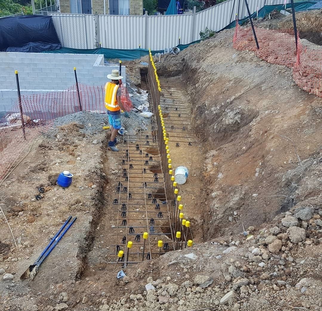 A Man is Standing on a Concrete Surface in Front of a House — TJ Concreting in Myocum, NSW