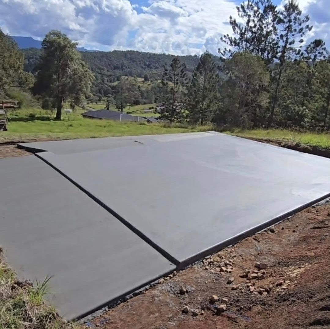 A Concrete Driveway is Being Built in Front of a Garage — TJ Concreting in Myocum, NSW