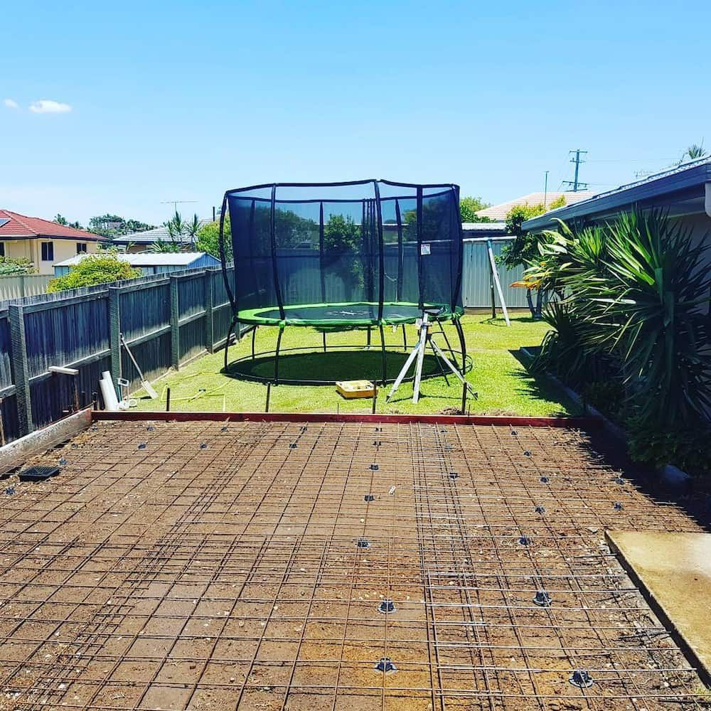 A Trampoline is Sitting in the Middle of a Backyard — TJ Concreting in Myocum, NSW