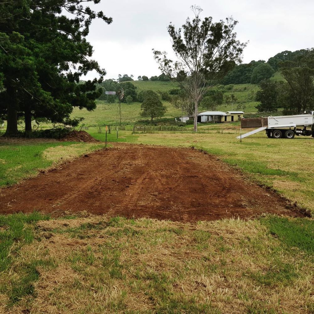 A White Truck is Parked in a Grassy Field — TJ Concreting in Myocum, NSW