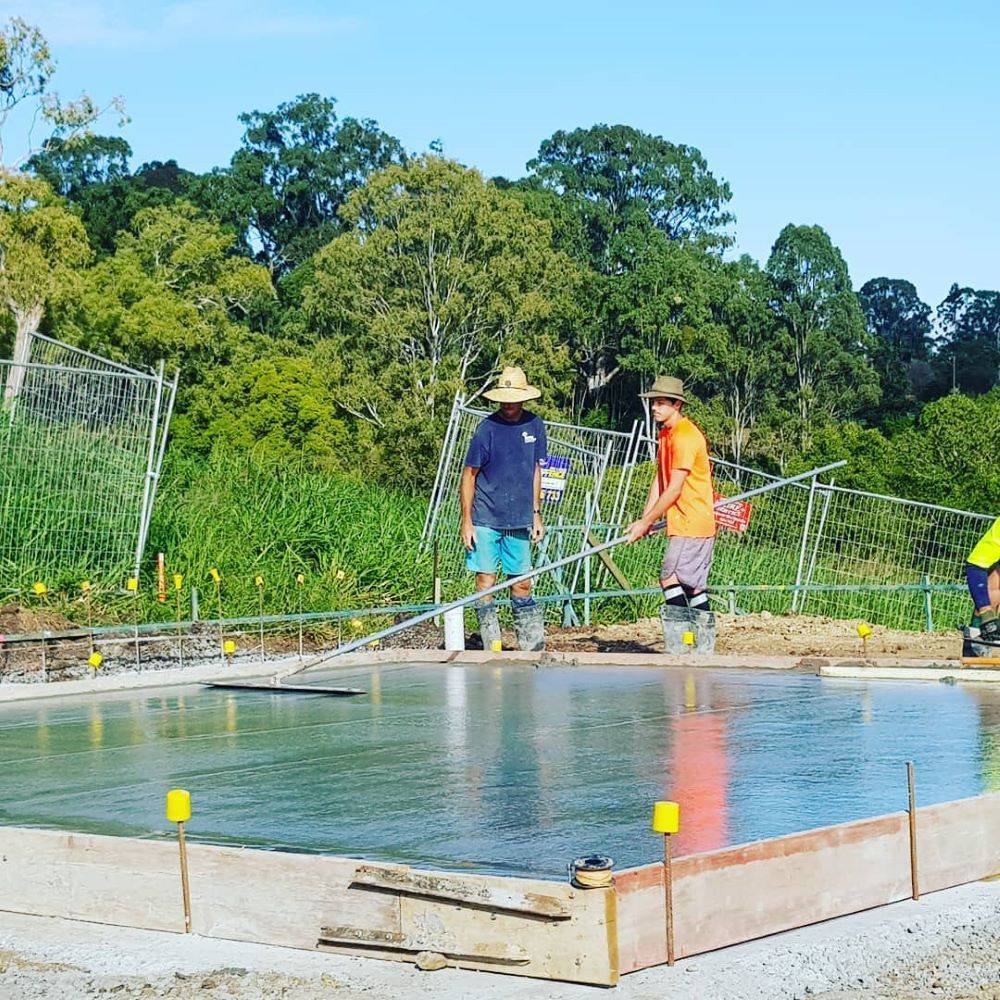 A Group of Construction Workers Are Working on a Concrete Slab — TJ Concreting in Myocum, NSW