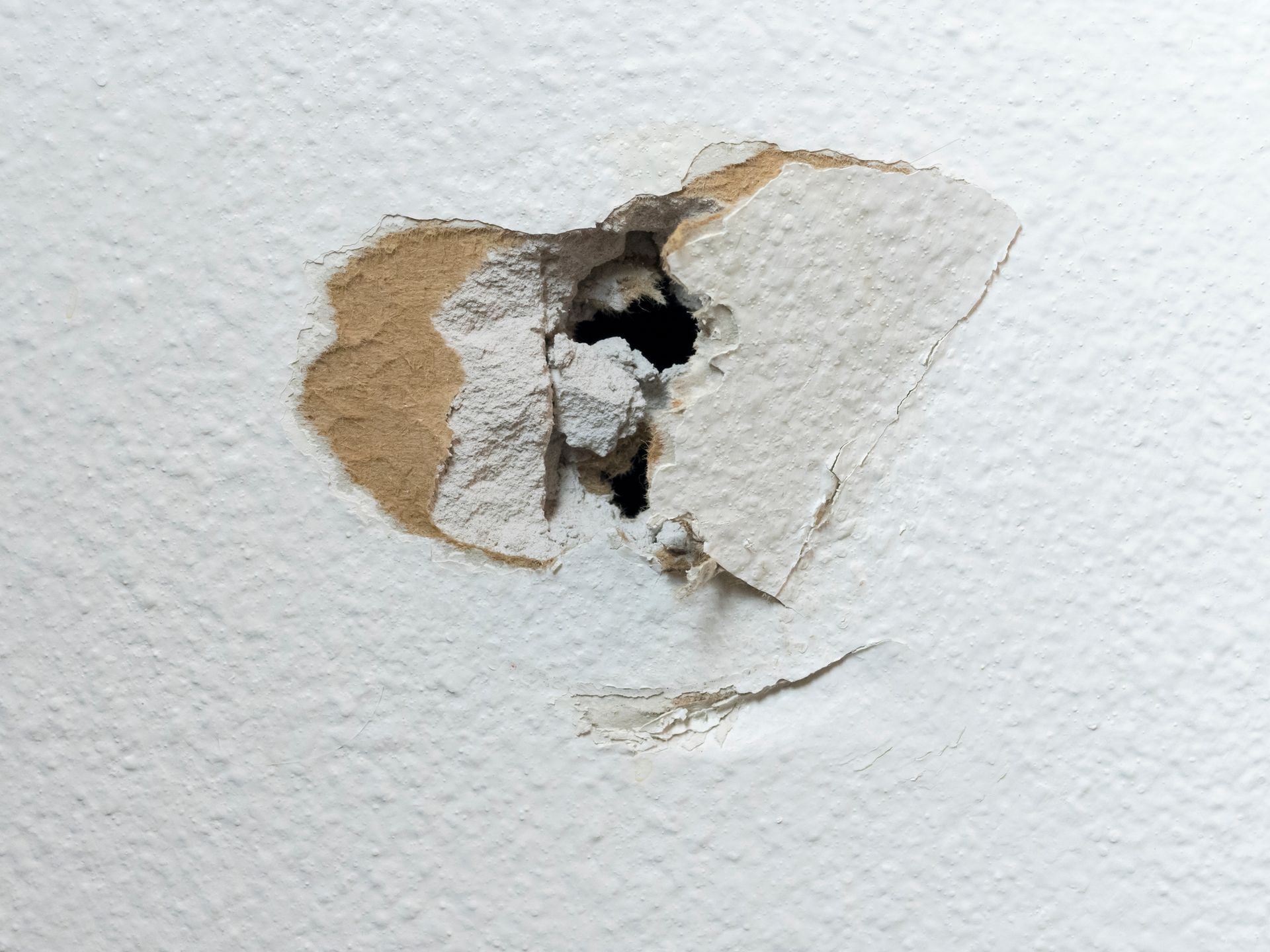 A hole in a white wall with a hole in it.