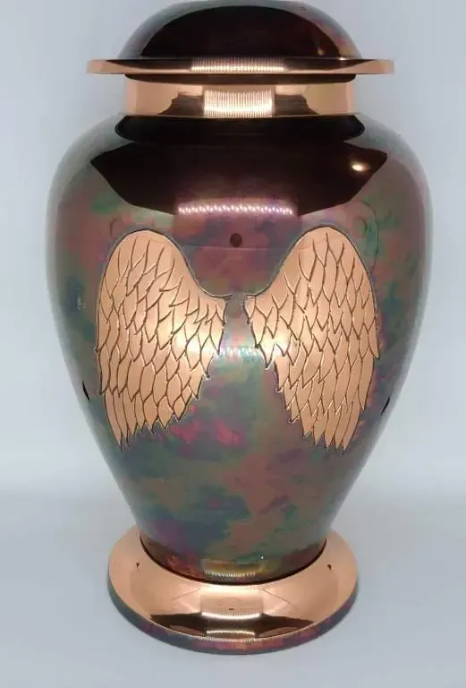 A large vase with wings on it is sitting on a table.