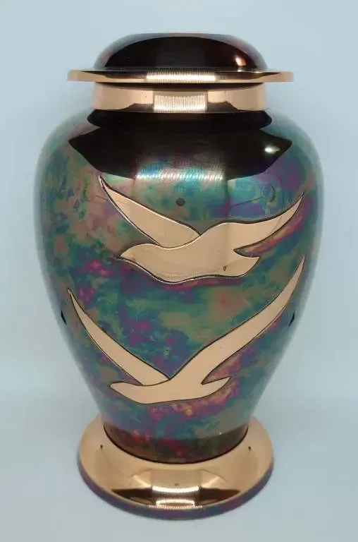 A vase with two birds on it is sitting on a table