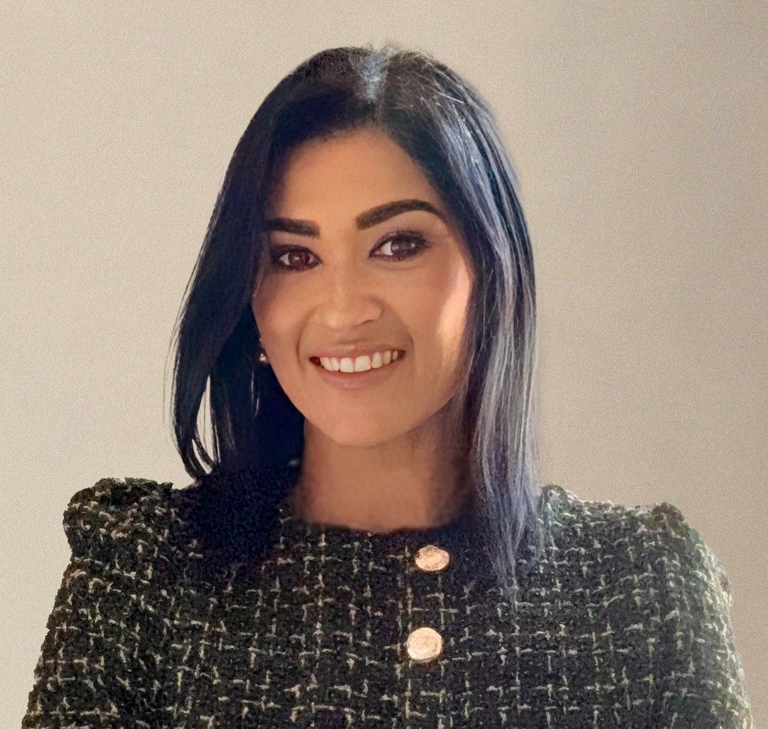 A woman is smiling for the camera and wearing a black jacket