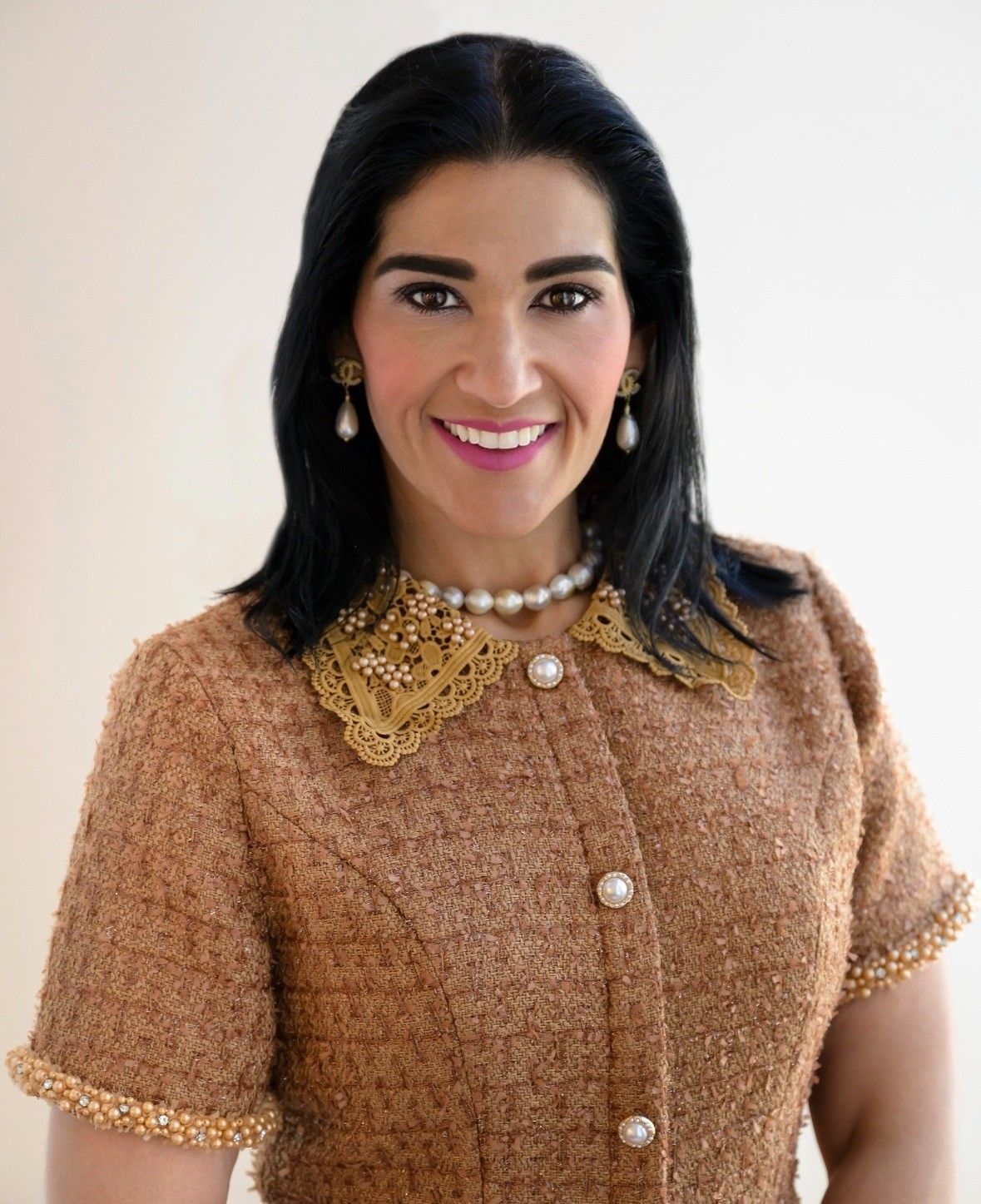 A woman is smiling for the camera and wearing a black jacket