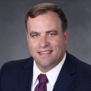 A man in a suit and tie is smiling for the camera.