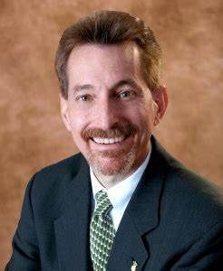A man in a suit and tie is smiling for the camera.