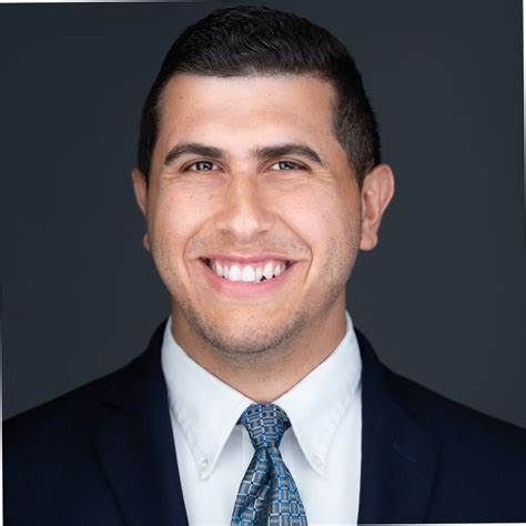 A man in a suit and tie is smiling for the camera.