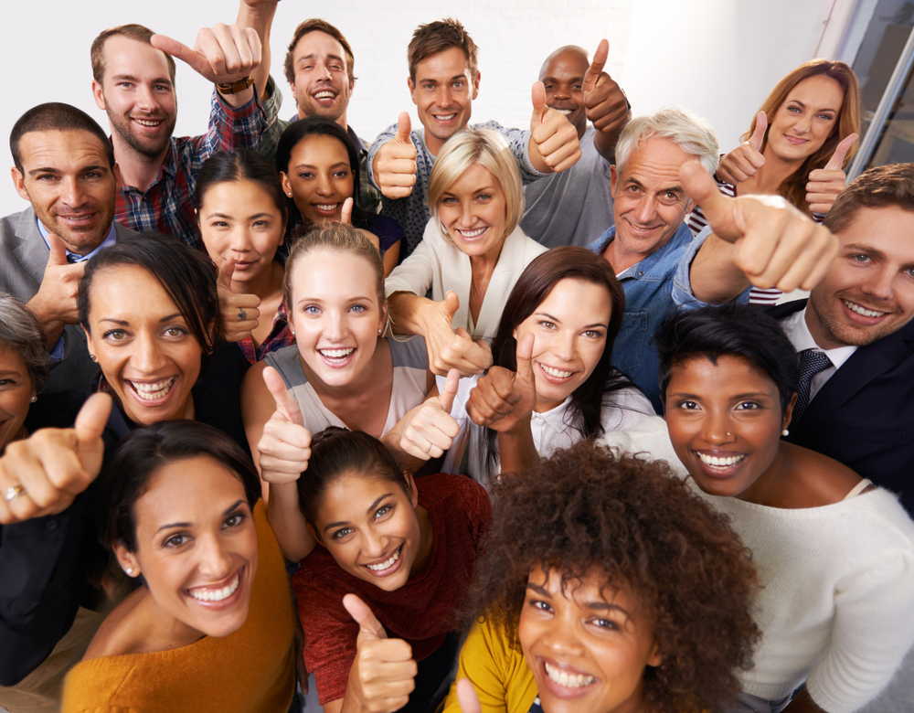 A large group of people are giving a thumbs up sign.
