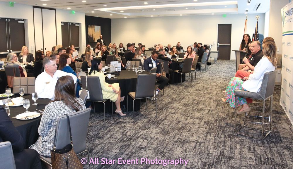 A large group of people are sitting at tables in a large room.