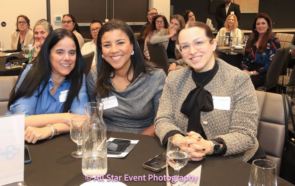 A group of women are sitting at a table with glasses of water.
