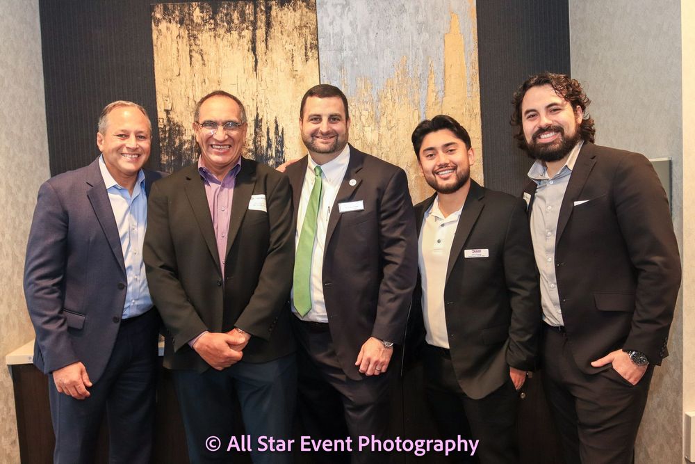 A group of men in suits and ties are posing for a picture.