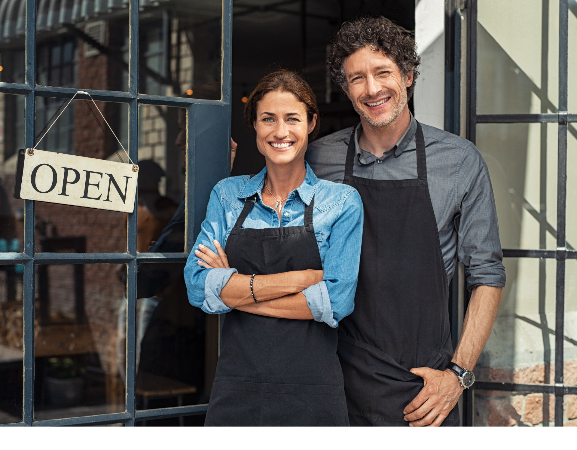 A man and a woman are standing in front of a restaurant.