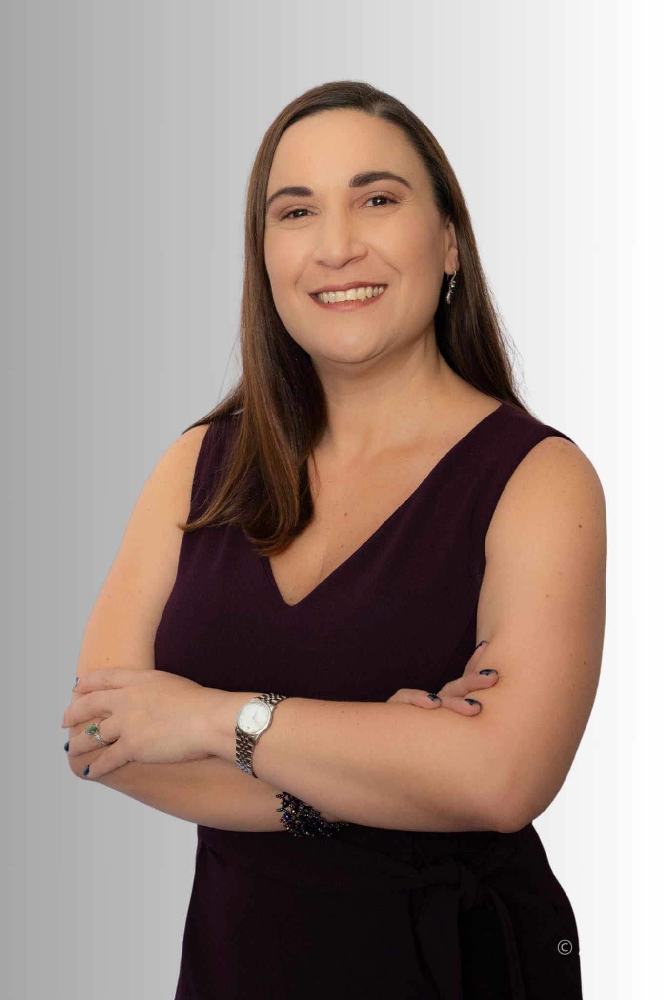 A woman in a purple dress with her arms crossed