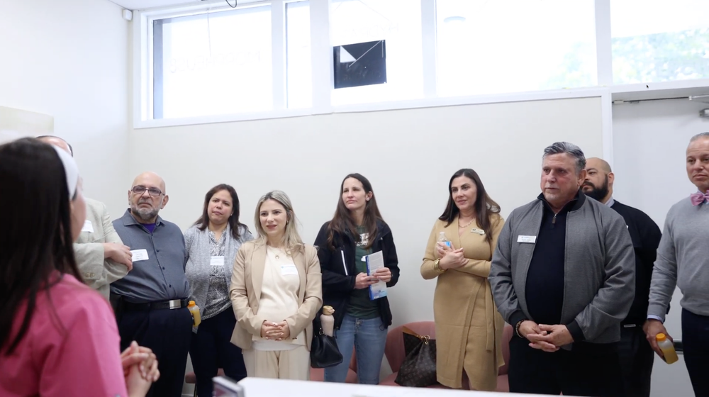 A group of people are standing around a table in a room.