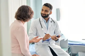 A doctor is talking to a patient in a hospital room.