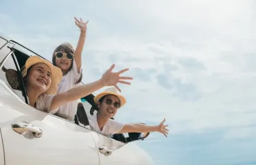 A family is looking out of the window of a car.