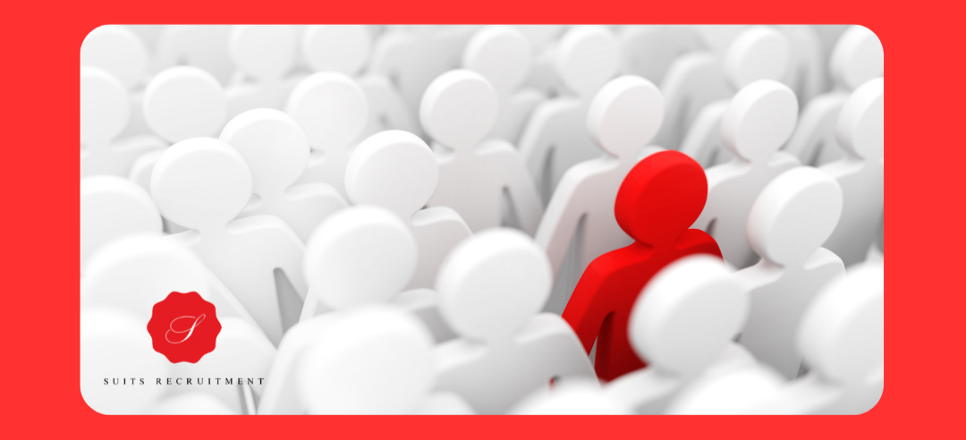A red person is standing in a crowd of white people