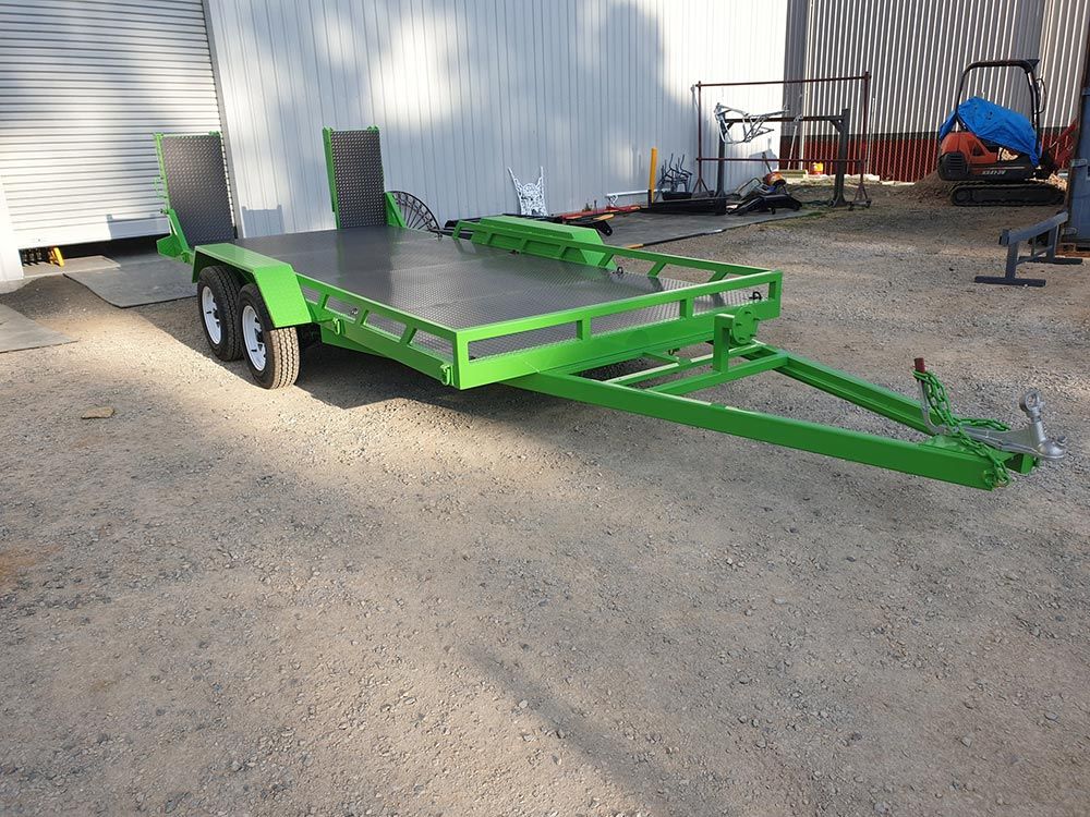 A Green Trailer Is Parked in A Gravel Lot in Front of A Building — ASSB Armidale Sand & Soda Blasting In  Armidale, NSW