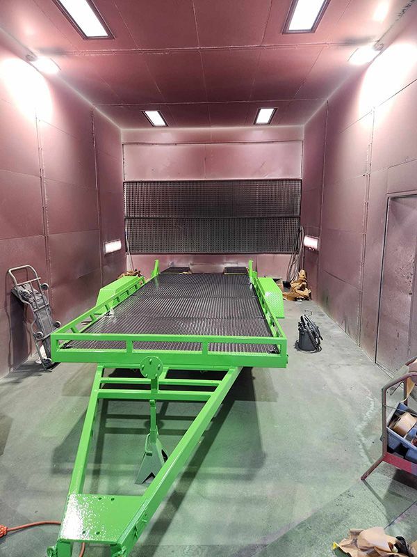 A Green Trailer Is Sitting Inside Of A Paint Booth — ASSB Armidale Sand & Soda Blasting In  Armidale, NSW