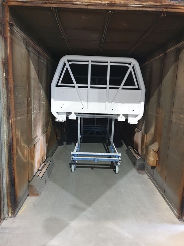 A White Ute Is Sitting Inside Of A Paint Area — ASSB Armidale Sand & Soda Blasting In  Armidale, NSW