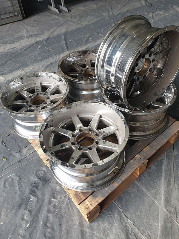 A Bunch Of Aluminum Wheels Are Sitting On Top Of A Wooden Pallet — ASSB Armidale Sand & Soda Blasting In  Armidale, NSW