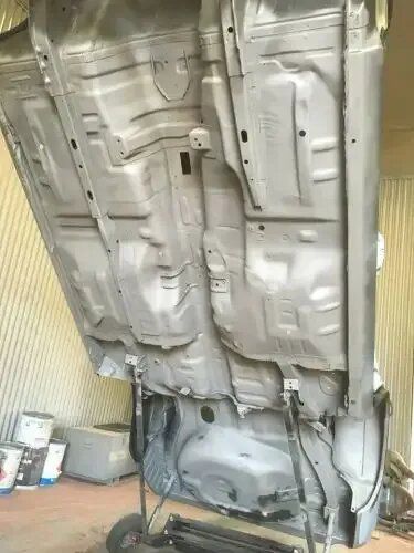 The Bottom of A Car Is Being Painted in A Garage — ASSB Armidale Sand & Soda Blasting In Tamworth, NSW