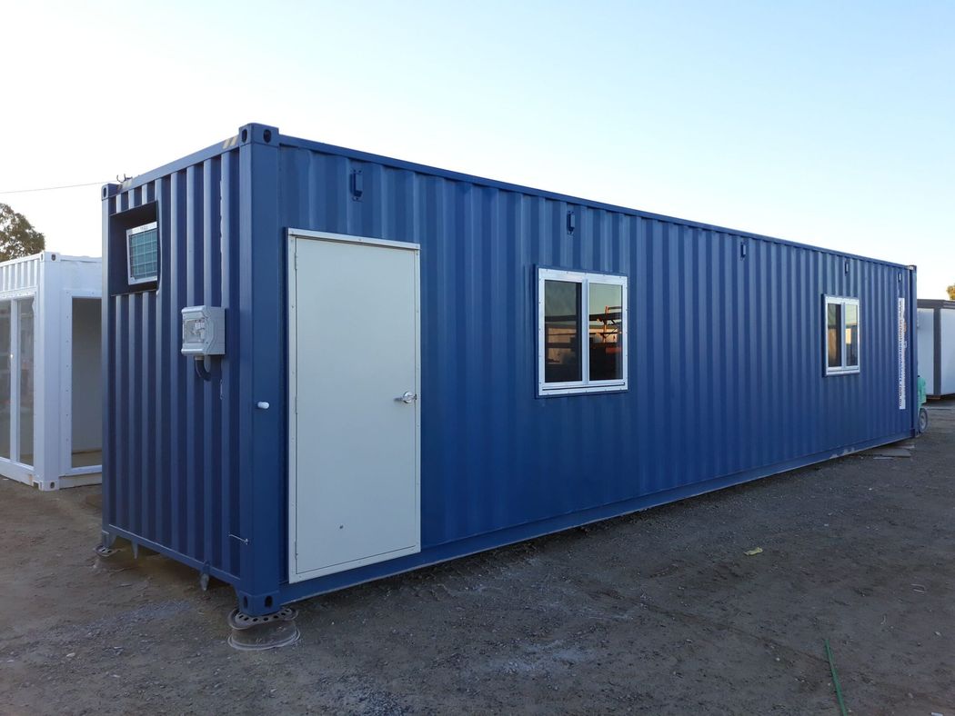 Blue 20-foot shipping container converted into a private office space with windows and door modifications for professional workspace