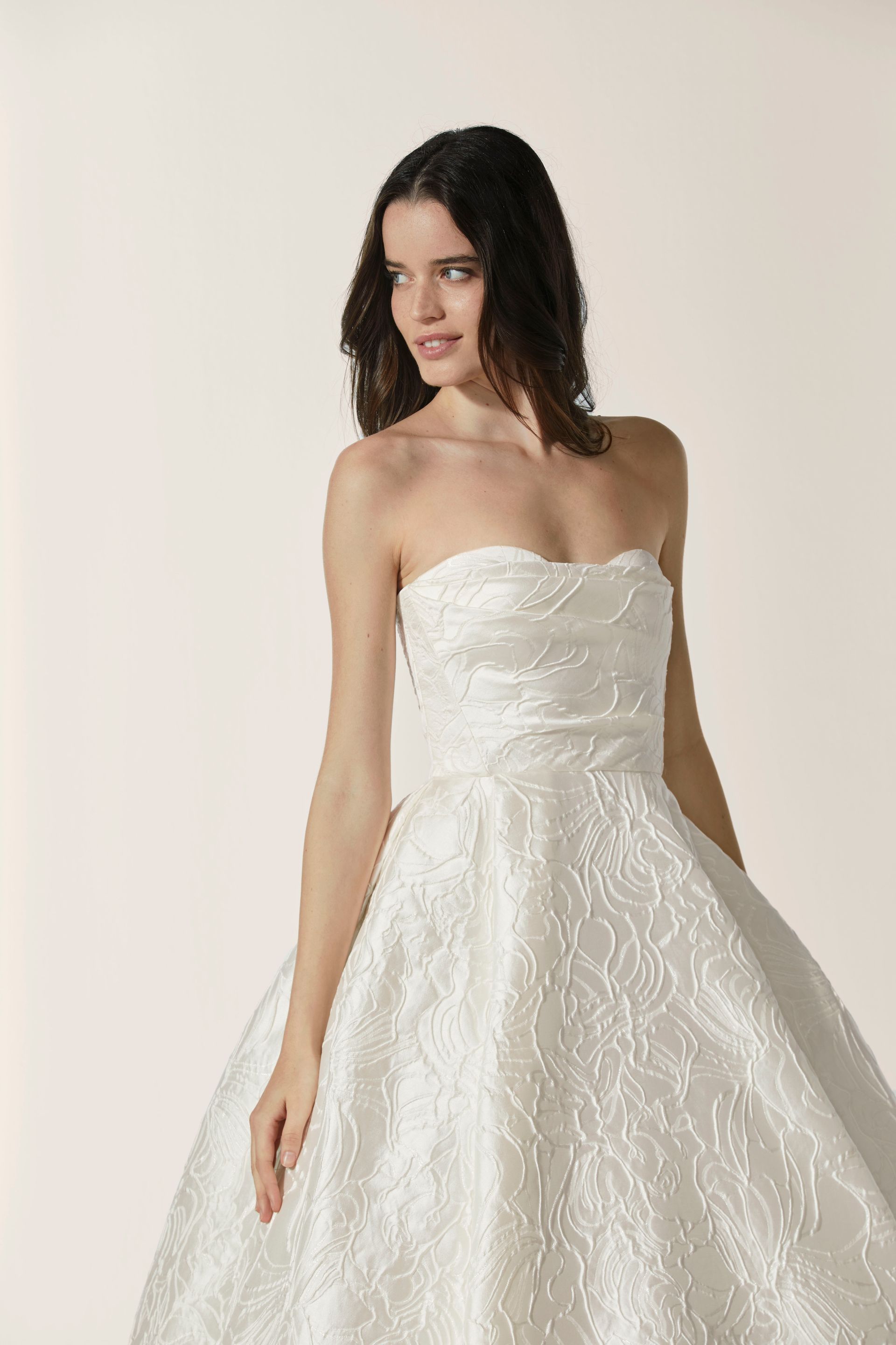 A woman is wearing a white wedding dress with a long train.