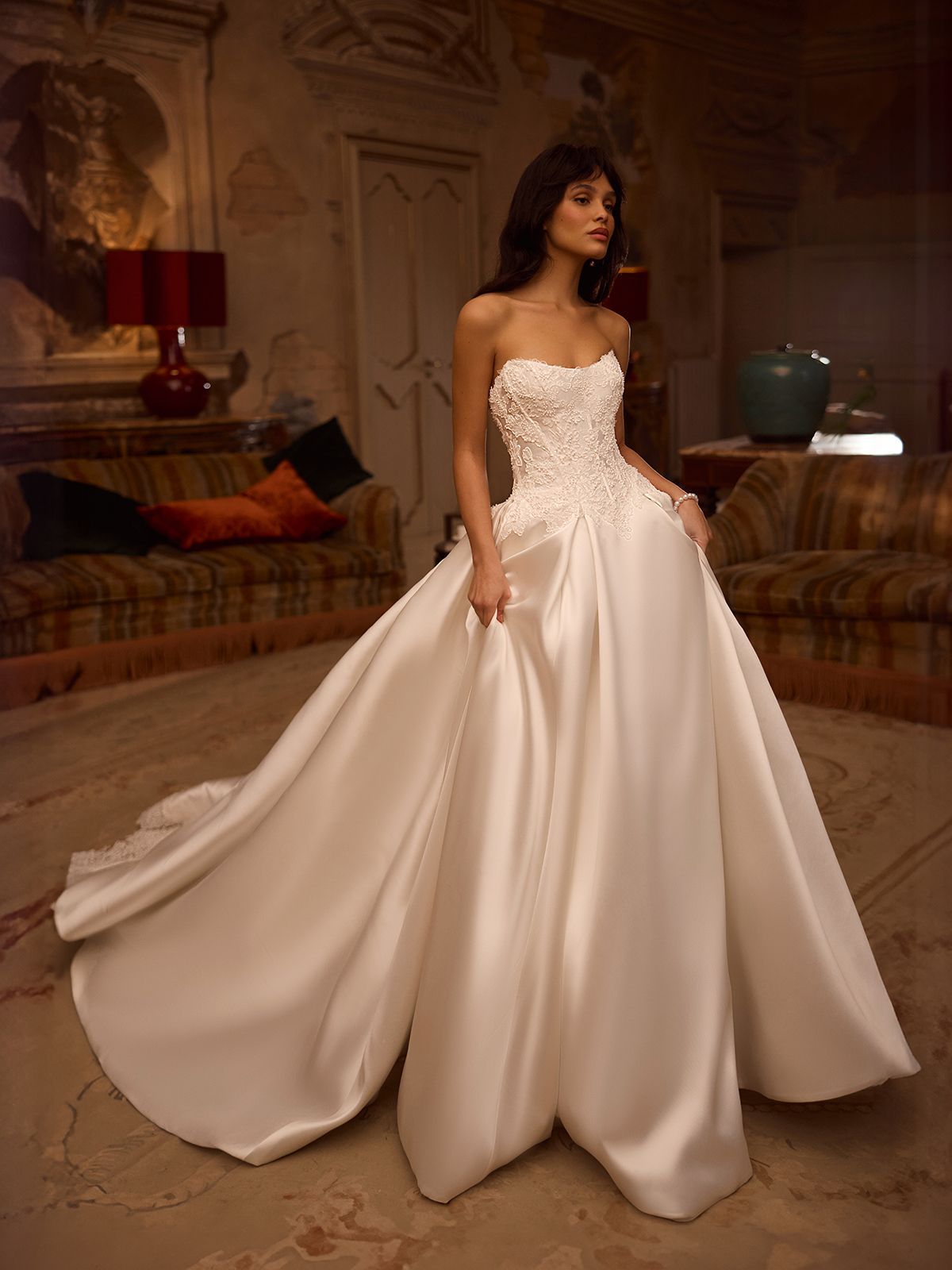 A woman in a wedding dress is standing in a room with a piano.