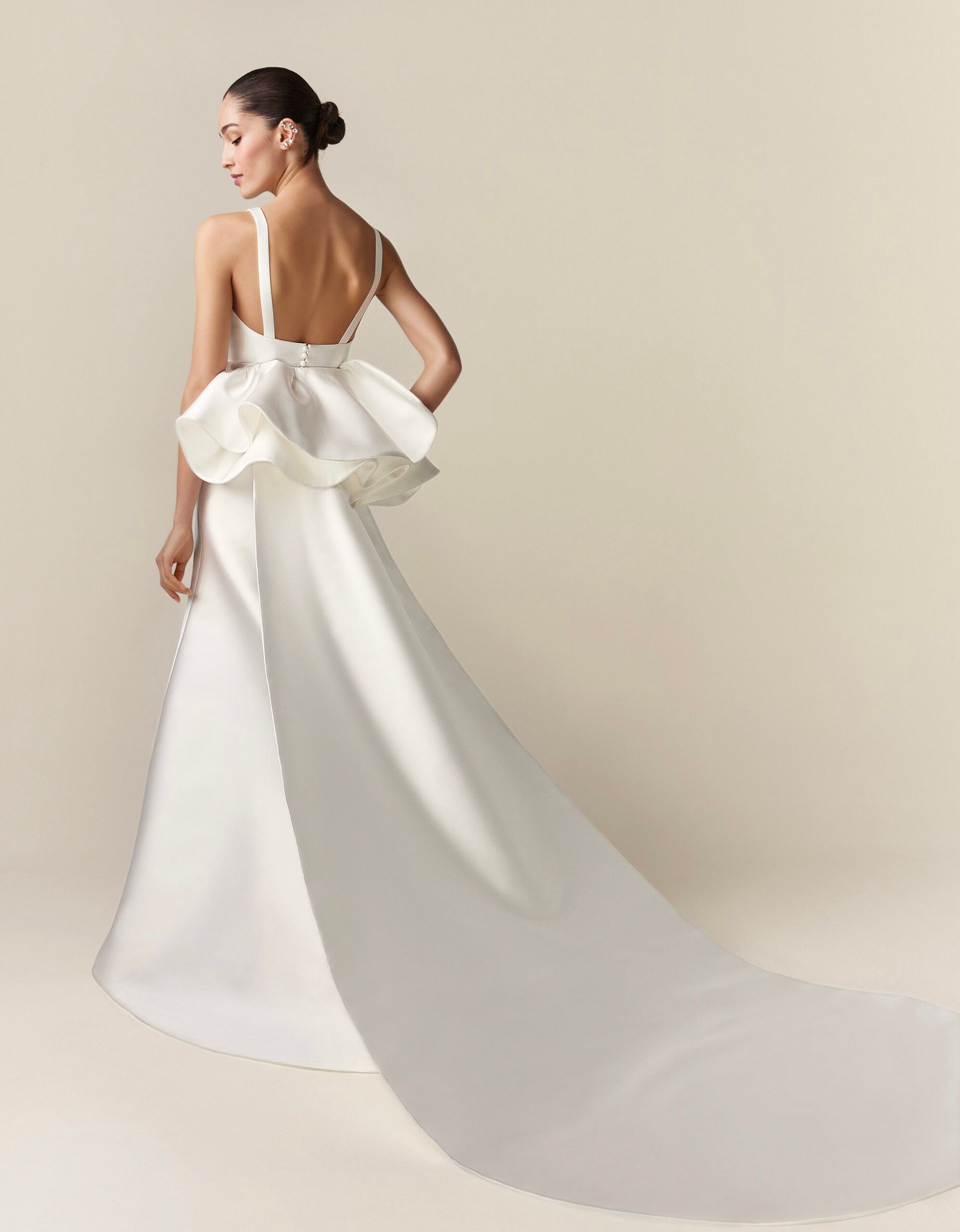 A woman is wearing a white wedding dress with a long train.